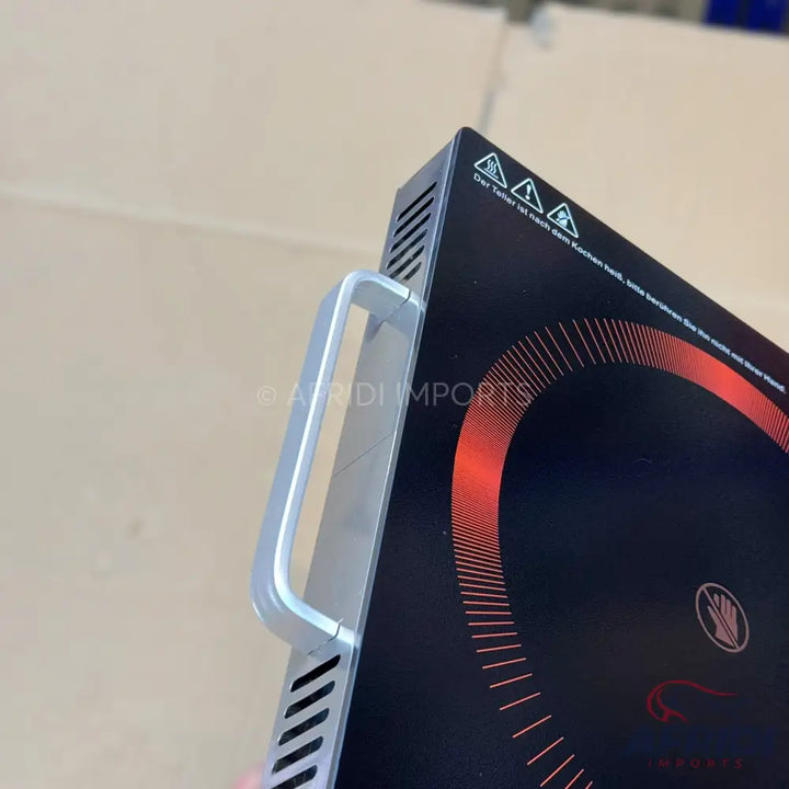 Black portable induction cooktop with a silver handle.