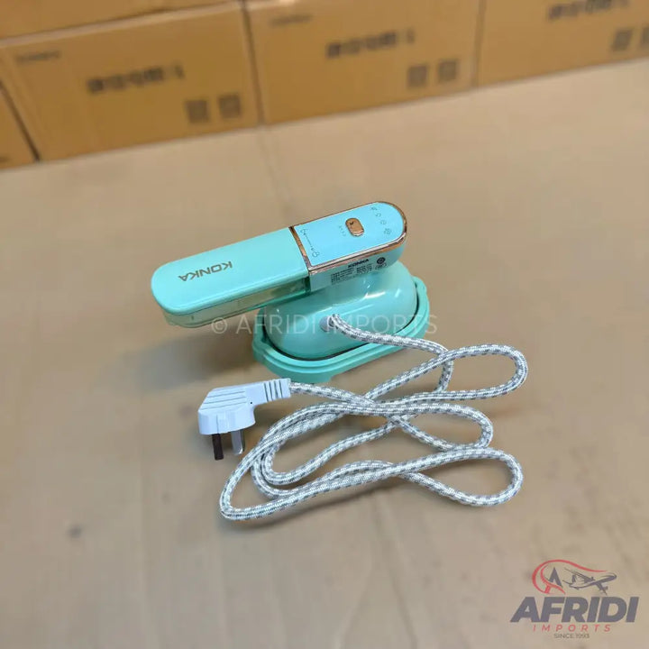 A mint green handheld steam iron with a braided power cord and a three-pin plug.