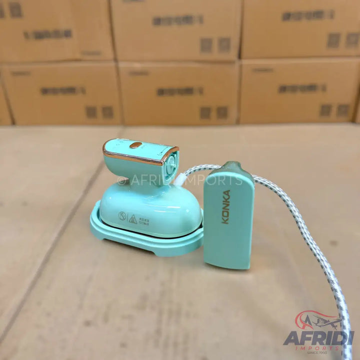 A light blue handheld garment steamer with rose gold accents.