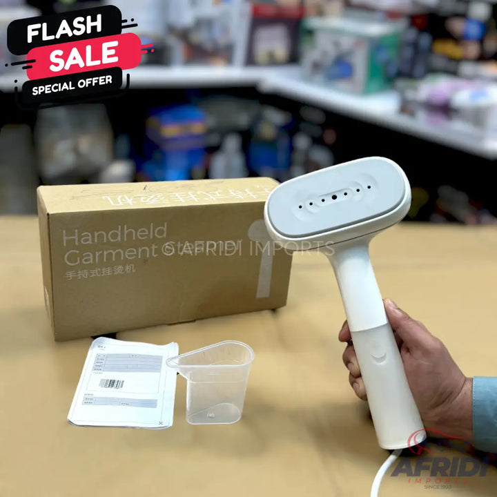 White handheld garment steamer with a water reservoir and steam vents.