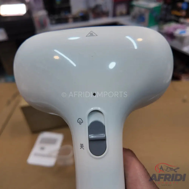 White handheld garment steamer with a slider switch.