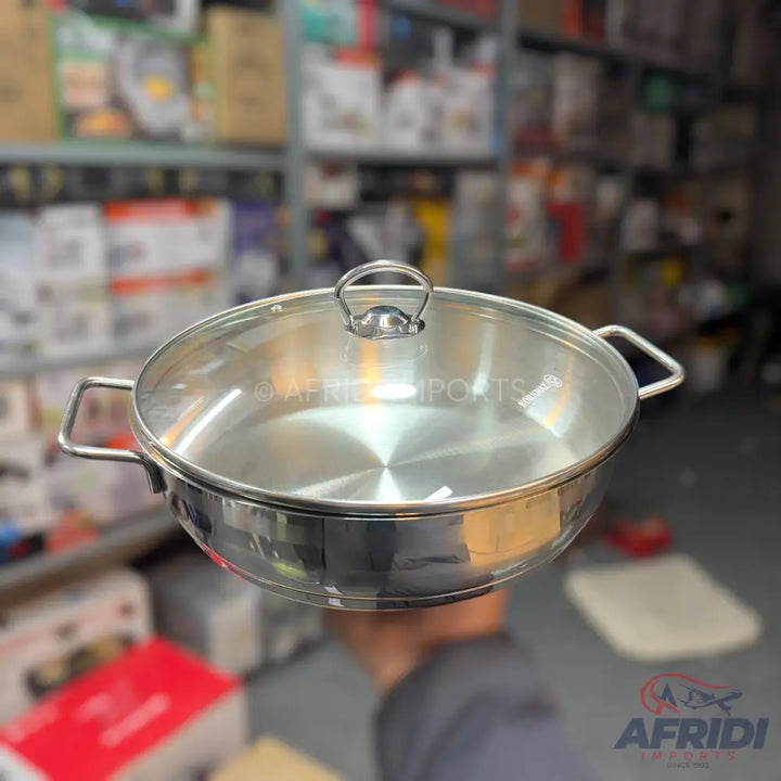 Stainless steel cooking pan with a clear glass lid and two side handles.