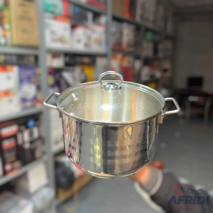 A stainless steel stockpot with a glass lid and two side handles.