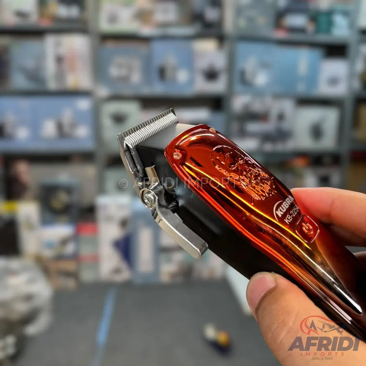 Metallic red and silver electric hair clipper.