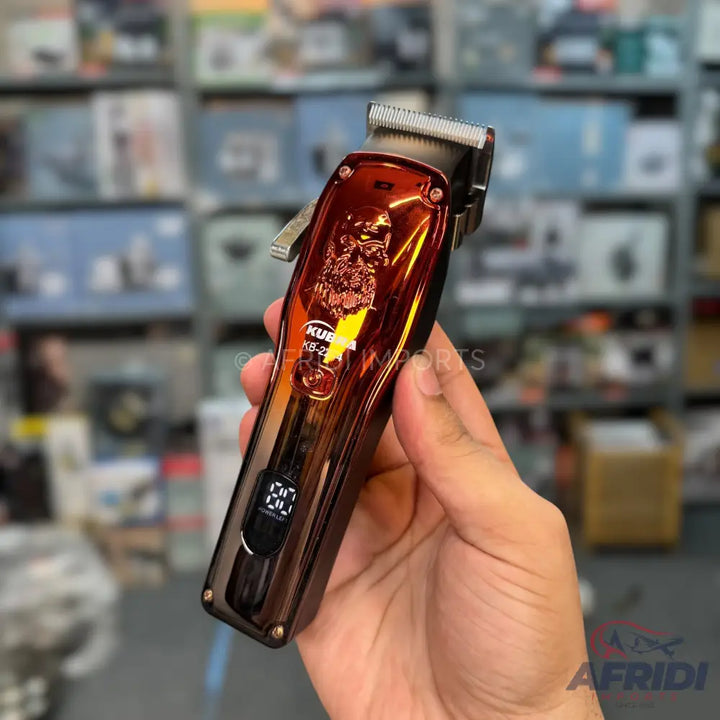 A dark metallic hair clipper with an engraved design and a digital display.
