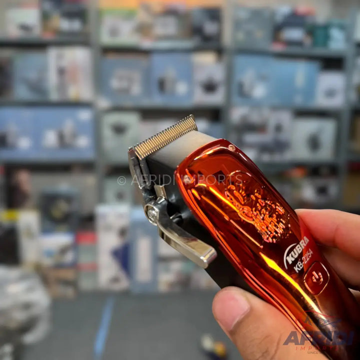 Red and black electric hair clipper with a metallic finish.