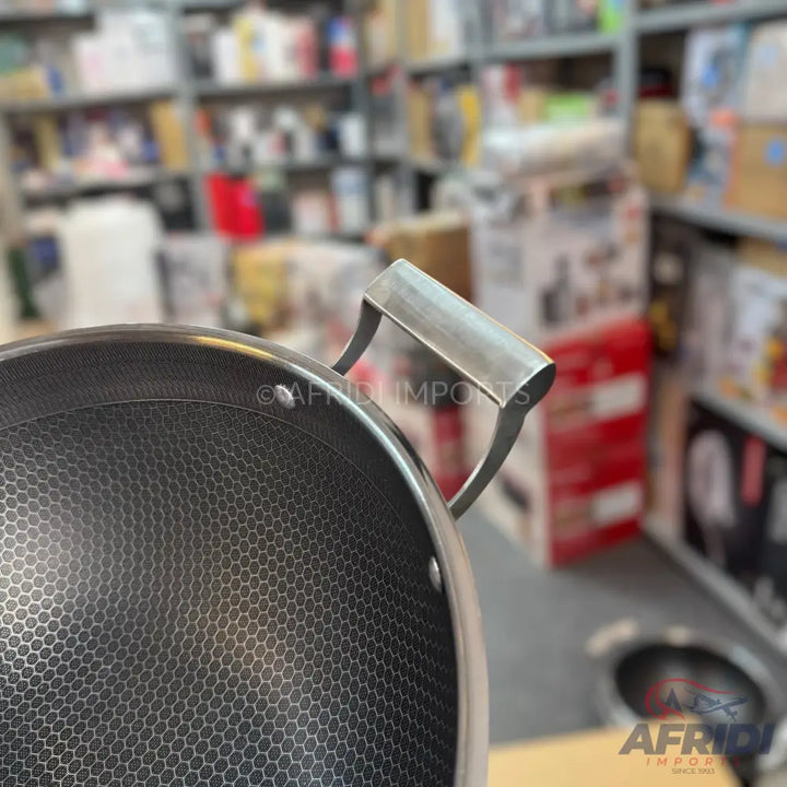 Black honeycomb-patterned non-stick wok with a short, wide metal handle.