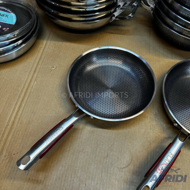 Stainless steel frying pan with a honeycomb textured non-stick surface and a red-accented handle.
