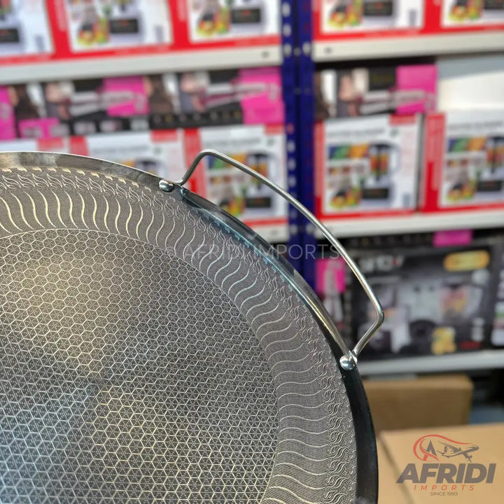 Perforated metal splatter screen with a handle.