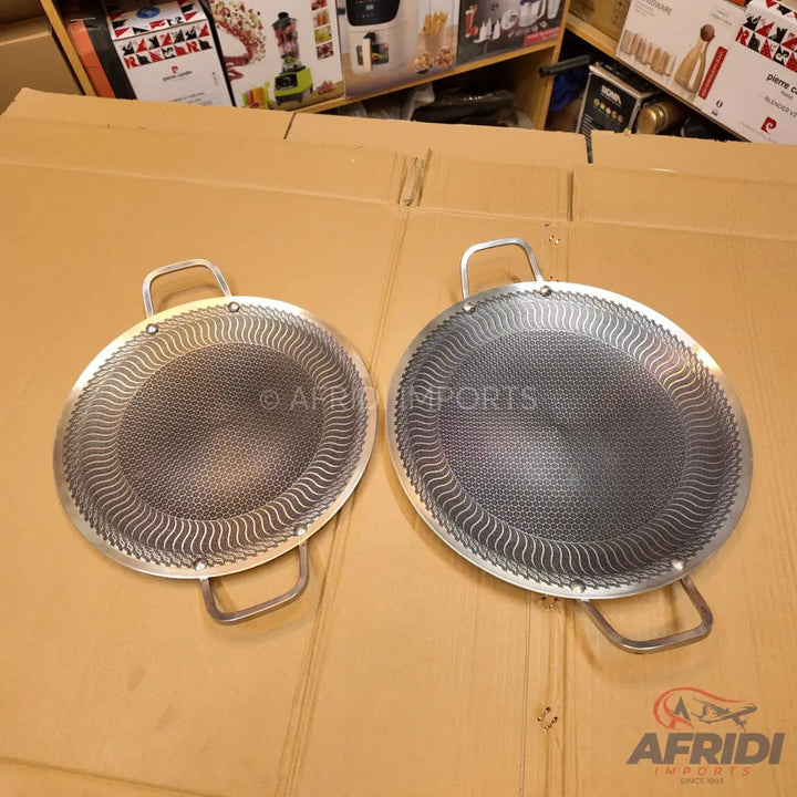 Two round, metal food sieves with handles.