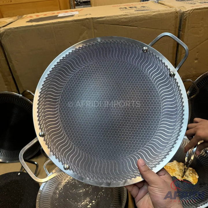Round, textured non-stick cooking pan with two handles.