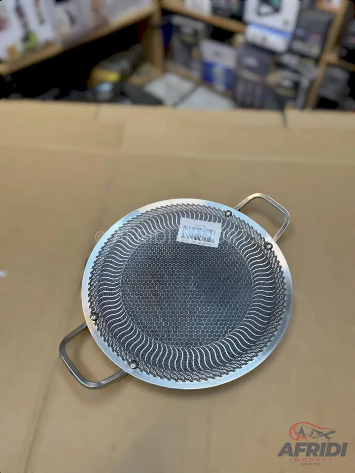 Round metal sifter with small handles and a honeycomb mesh pattern.