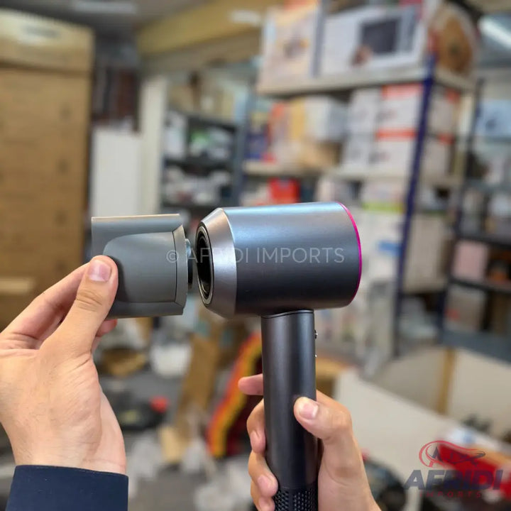 A black and gray hair dryer with a detachable nozzle.