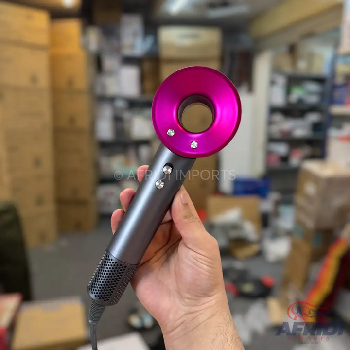 A dark gray and fuchsia pink hair dryer with two silver buttons on the handle.