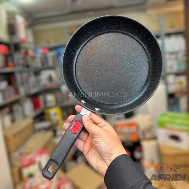 Black non-stick frying pan with a detachable handle.