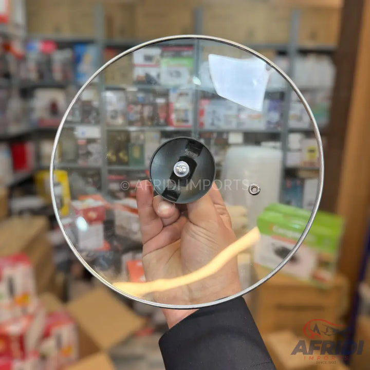 A clear round glass pot lid with a black knob handle.