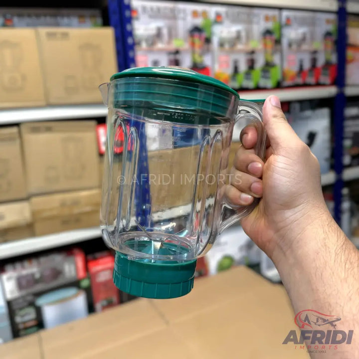 A clear plastic blender jar with a green lid and base.