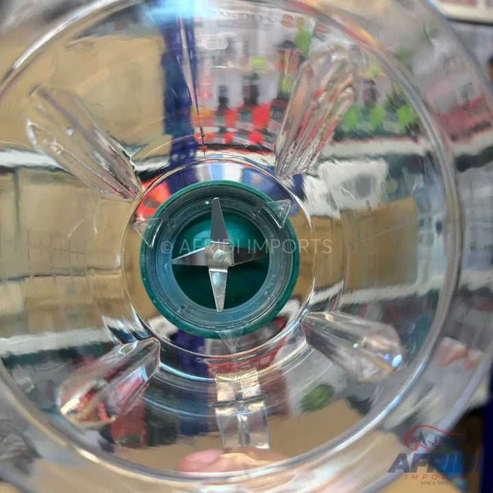 A clear plastic blender jar with a four-pronged metal blade assembly at the bottom.