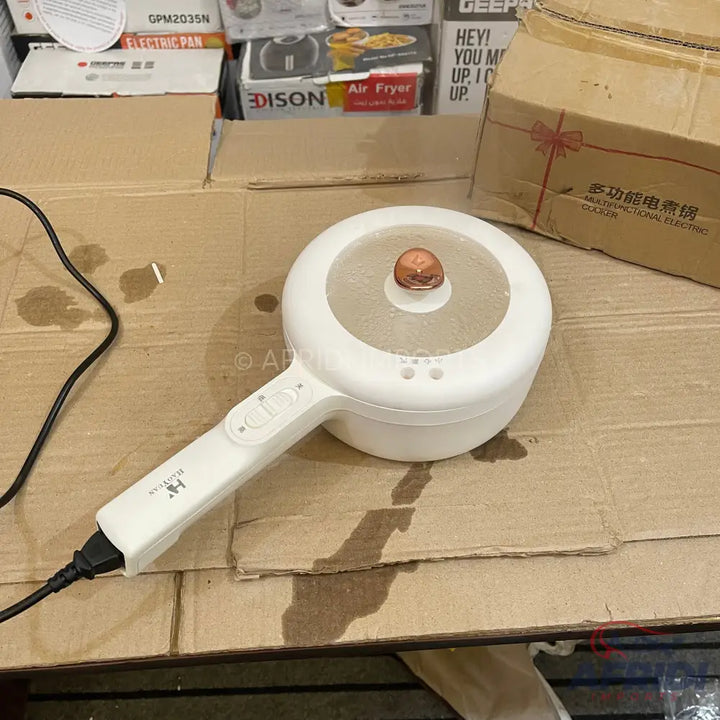 White electric cooking pot with a handle and transparent lid.
