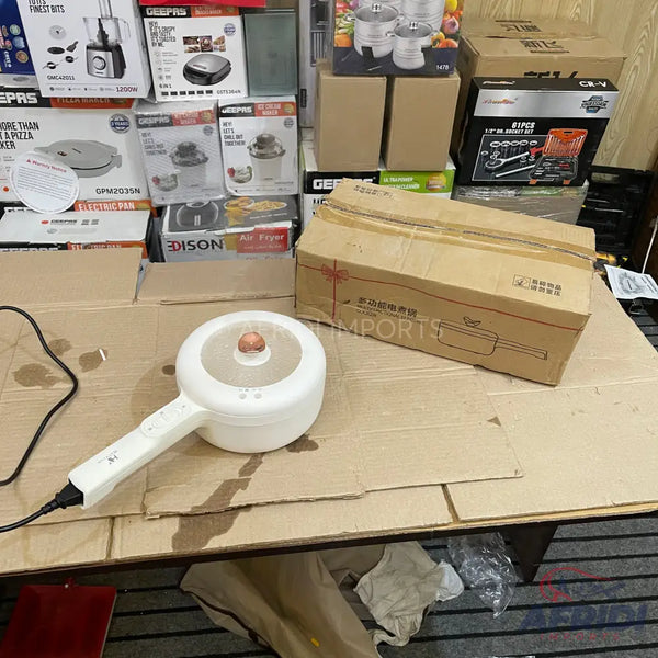 White electric cooking pot with a long handle and transparent lid.