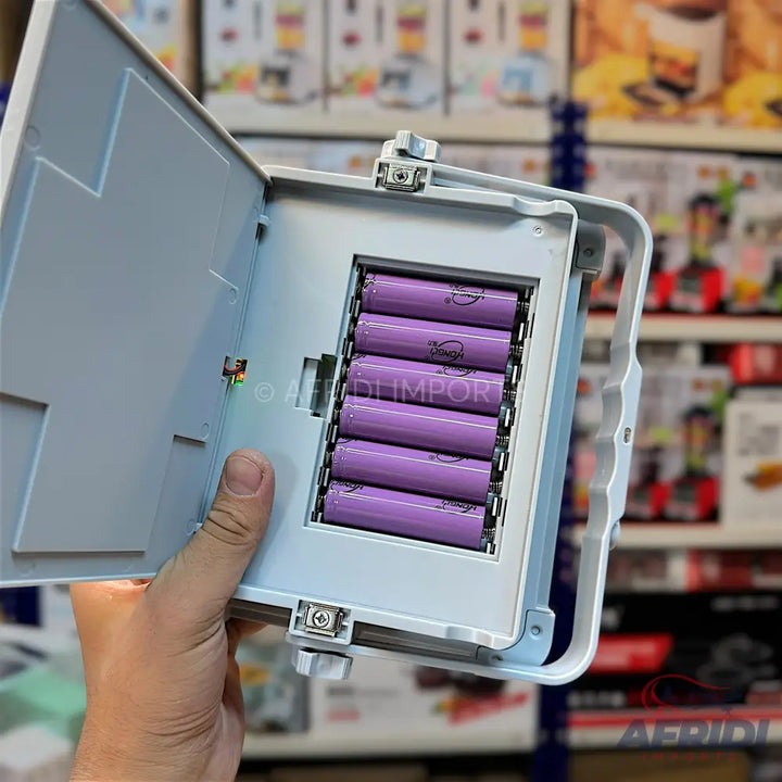 An open battery compartment with six purple cylindrical batteries.