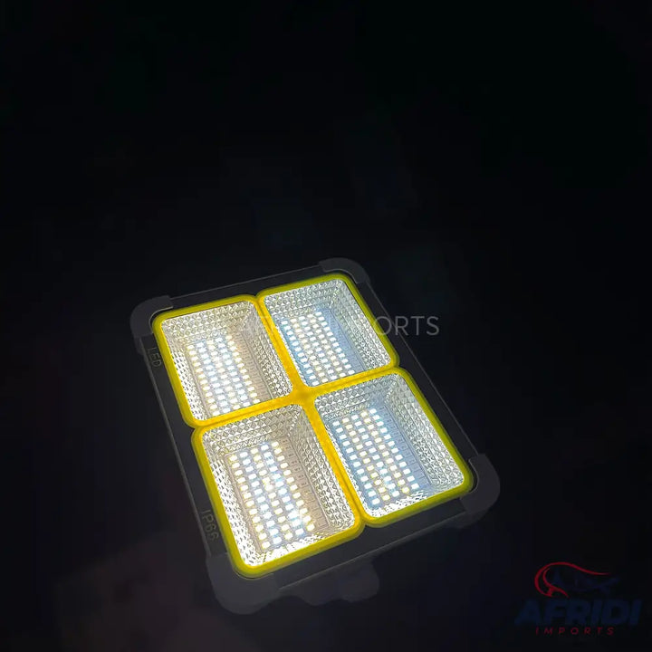 A multi-panel LED solar floodlight with a black frame and yellow dividers.