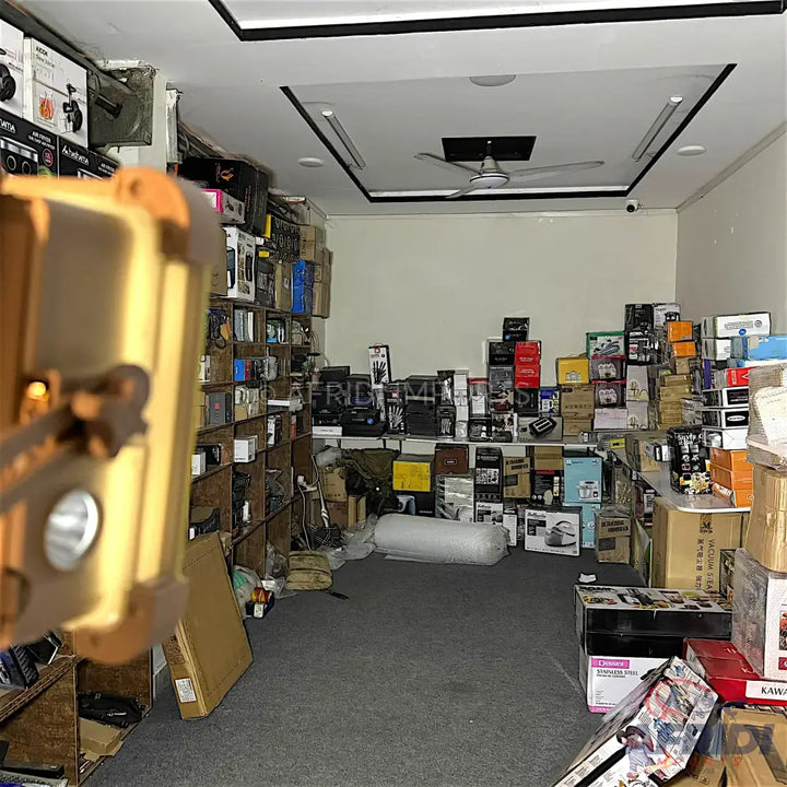 A cluttered storage room filled with boxed goods and electronics.