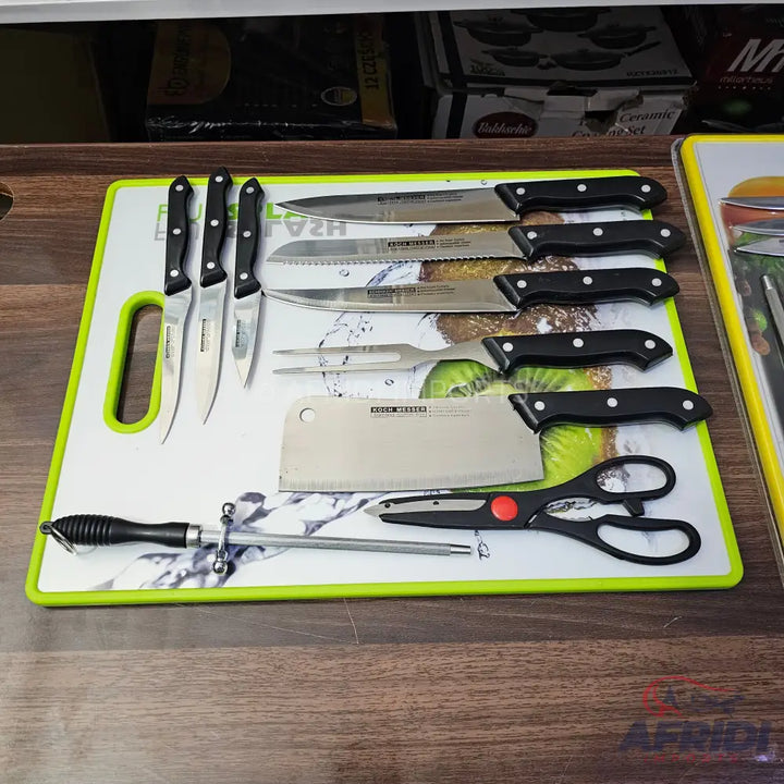 A diverse set of kitchen knives and tools on a cutting board.