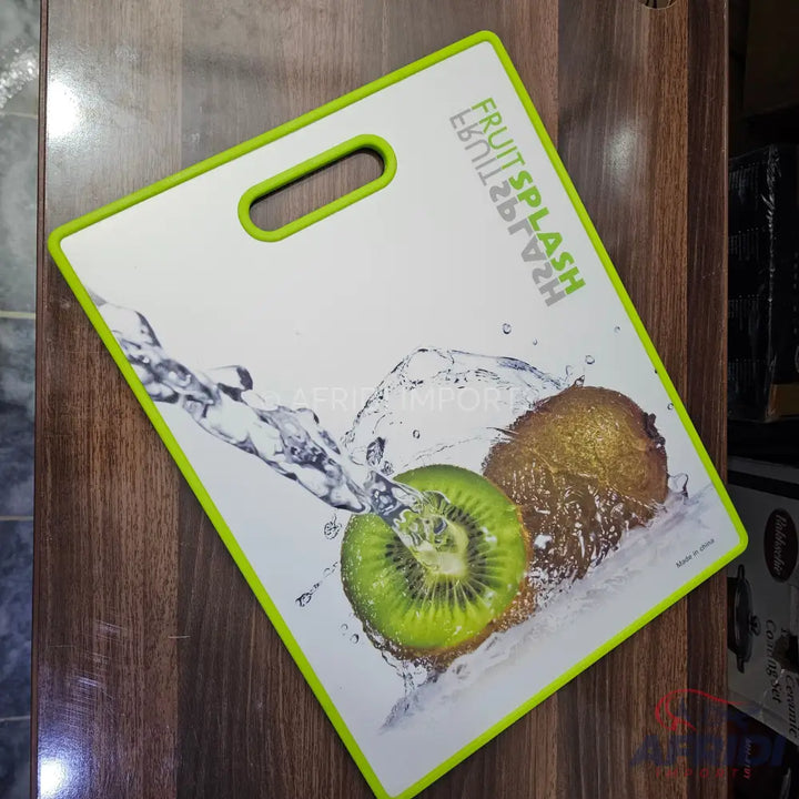 White cutting board with a green trim and a kiwi fruit design.