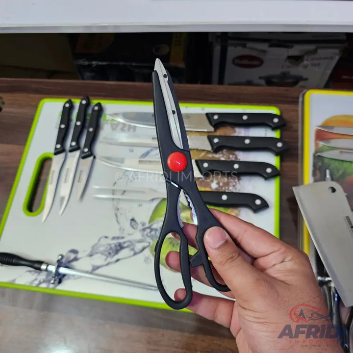Black-handled kitchen shears with a red pivot screw and serrated blade.