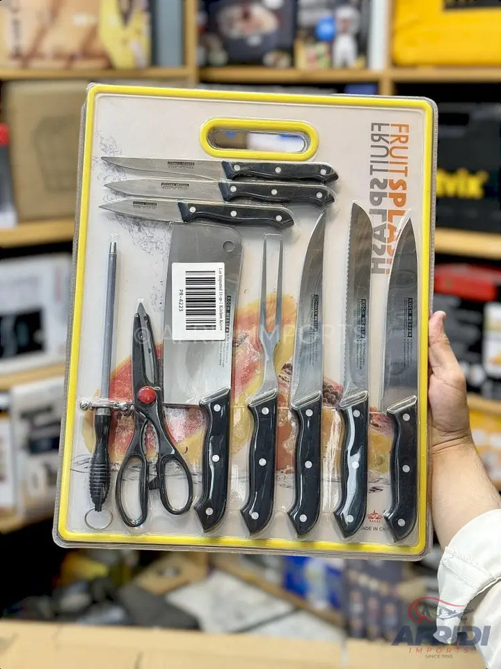 A 12-piece knife set with black handles, including a sharpening steel, kitchen shears, carving fork, and various knives for different culinary tasks, packaged in a clear plastic case with a yellow border and handle.