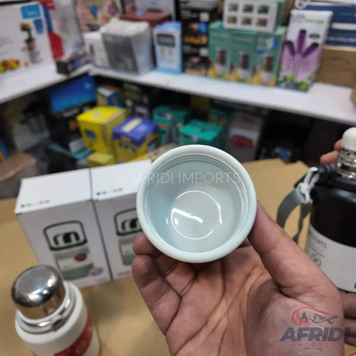An open white plastic cap of a thermos bottle.