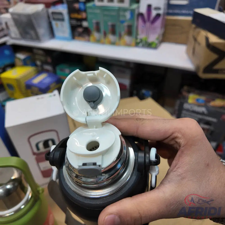 Black and silver stainless steel vacuum flask with a white flip-top lid and a grey drinking spout.