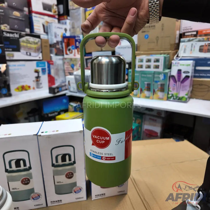 Green vacuum cup with a stainless steel interior and a carrying handle.
