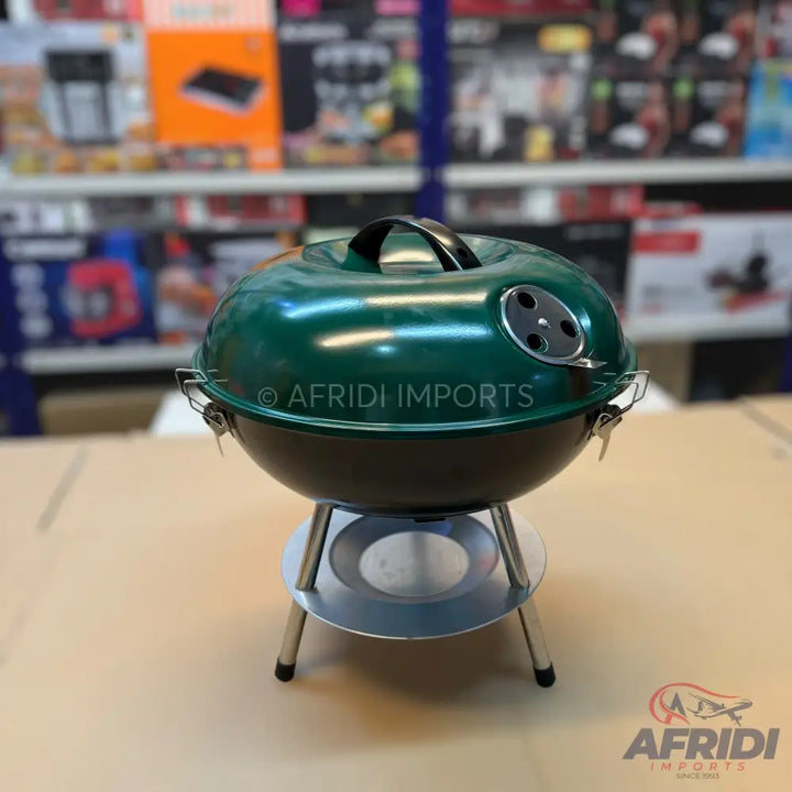 A green and black portable charcoal barbecue grill.