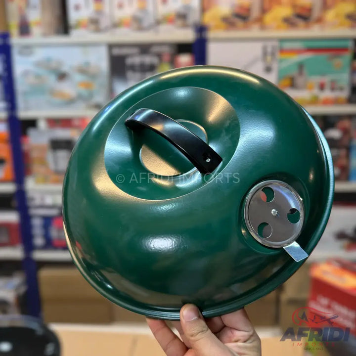 A dark green domed grill lid with a black handle and a silver adjustable vent.