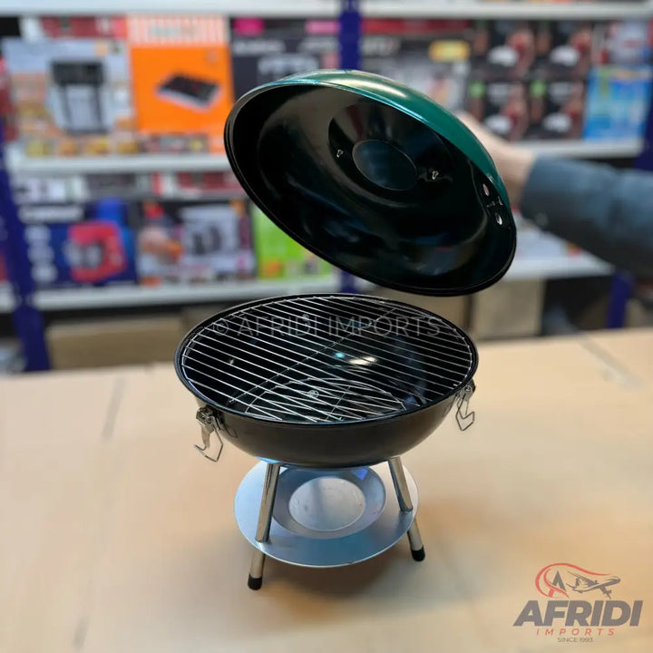 Black kettle-style charcoal grill with a dark green lid.