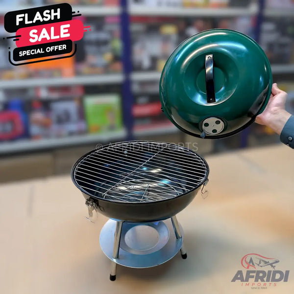 A portable charcoal grill with a removable green lid.