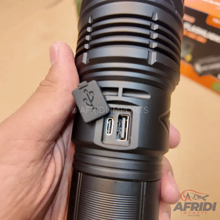 Black flashlight with USB-A and USB-C charging ports.