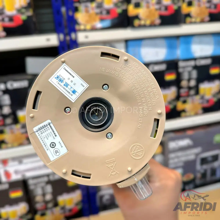 The underside of a beige electric kettle with power specifications and regulatory labels.