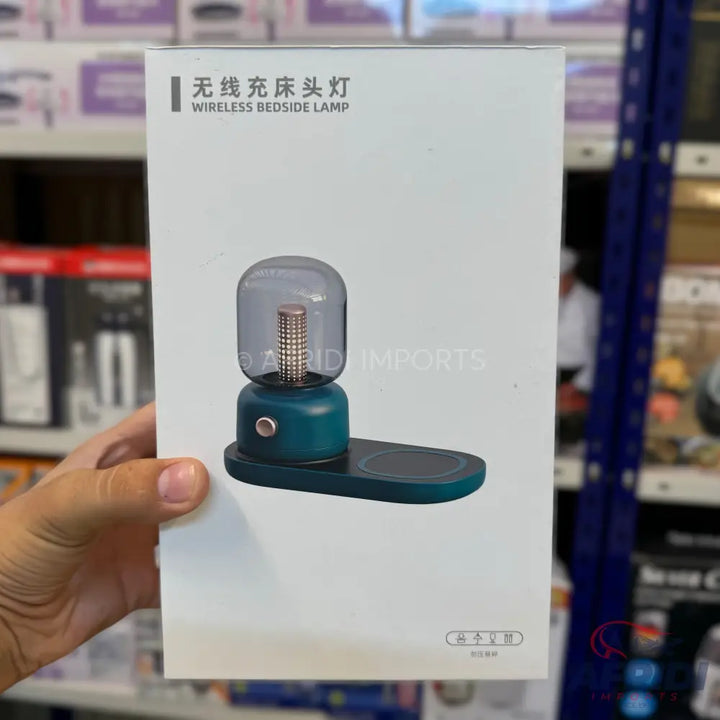 Wireless bedside lamp with a teal base and a clear, domed top enclosing a textured light source, featuring a built-in wireless charging pad.