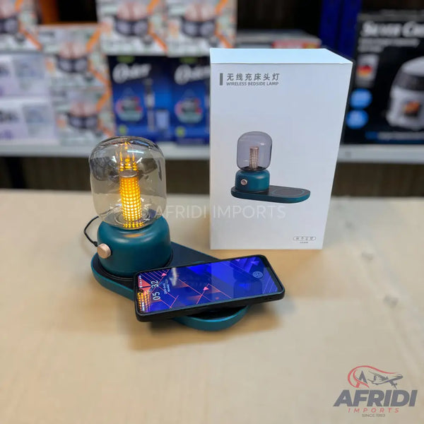 Teal wireless bedside lamp with a clear glass bulb and integrated phone charging pad.