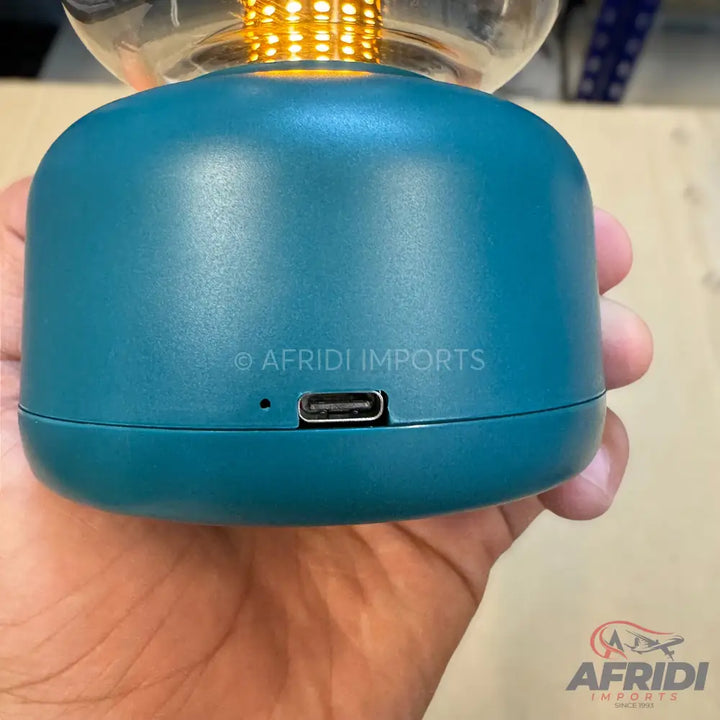 Teal blue portable lamp with a USB-C charging port.