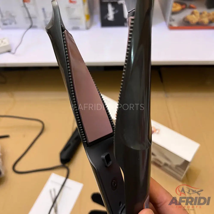 Dark grey hair straightener with pink ceramic plates.