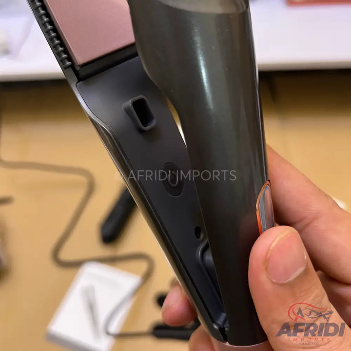 A dark grey and rose gold hair straightener with ceramic plates.