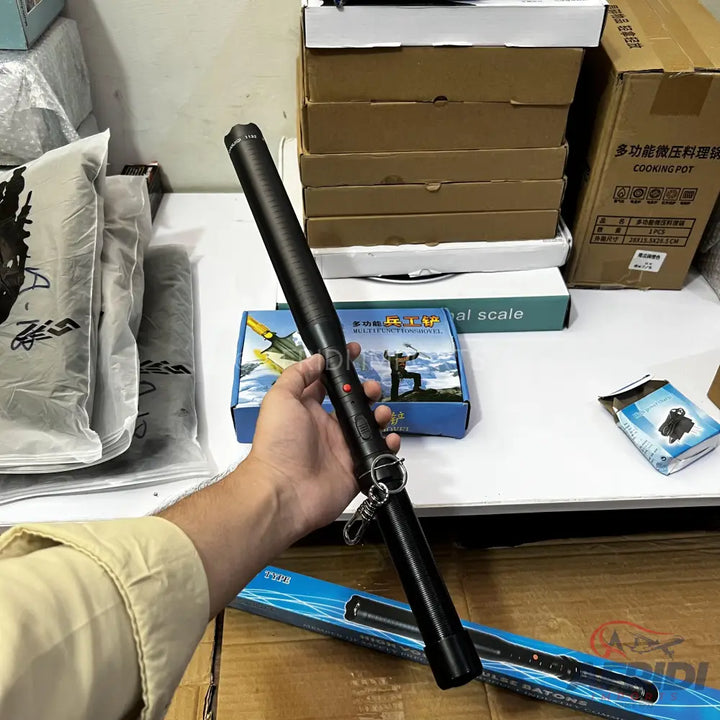 Black telescopic baton with a keyring attached.
