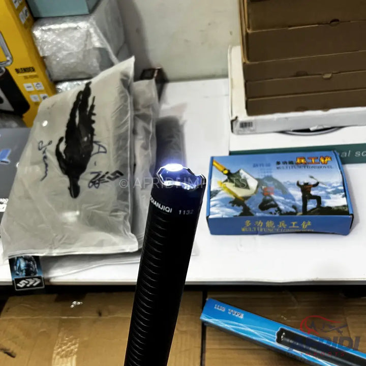 Black ribbed stun baton with a bright white light at the tip.