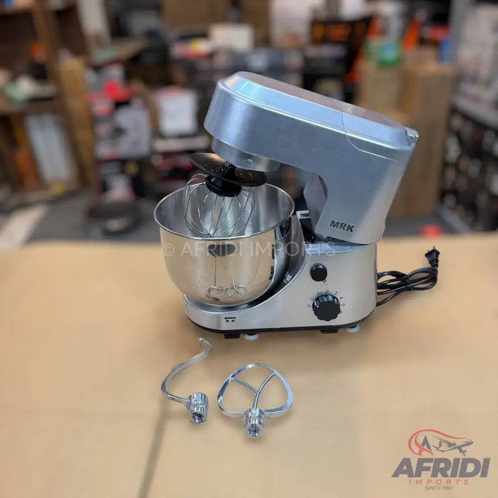 Silver stand mixer with a stainless steel bowl and two additional attachments.
