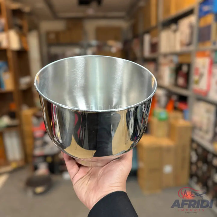 Shiny silver metal mixing bowl held in a hand.