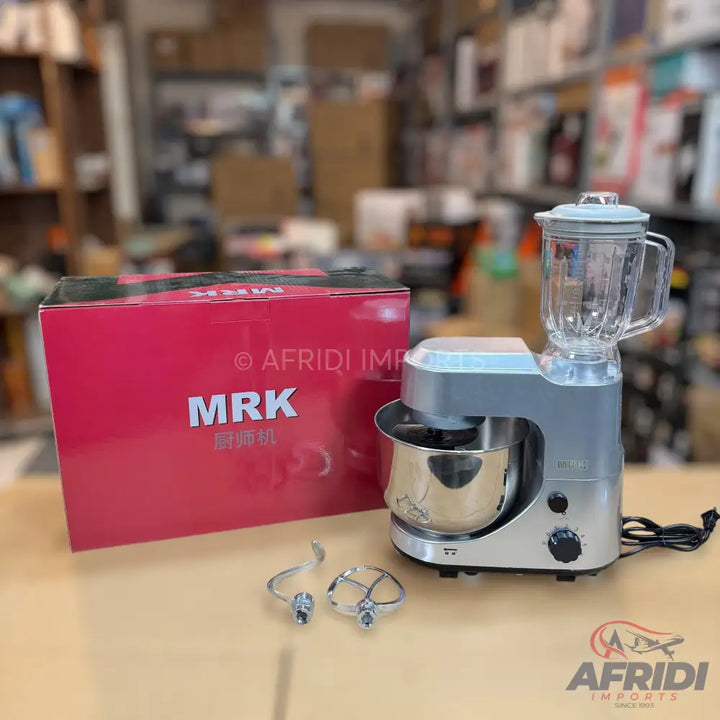 Silver stand mixer with a blender attachment, stainless steel bowl, and two mixing attachments.